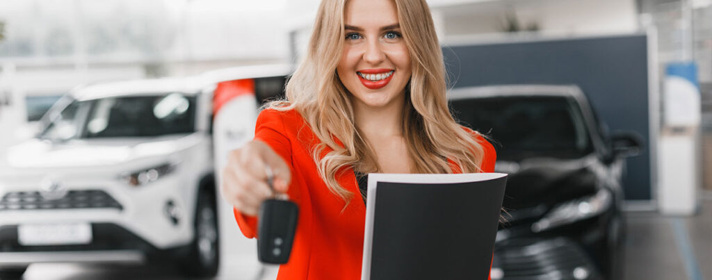 a woman holding a car key and smiling