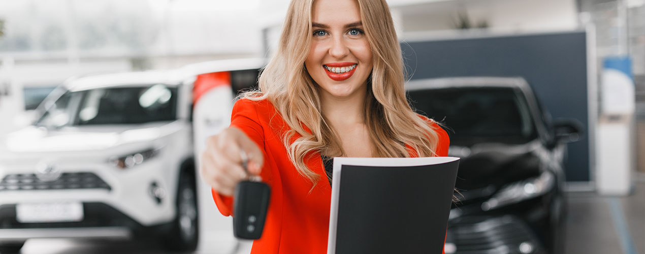 a woman holding a car key and smiling